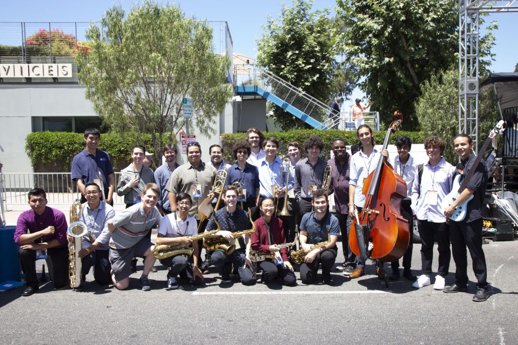 A group of students and their teachers pose for a photo with musical instruments